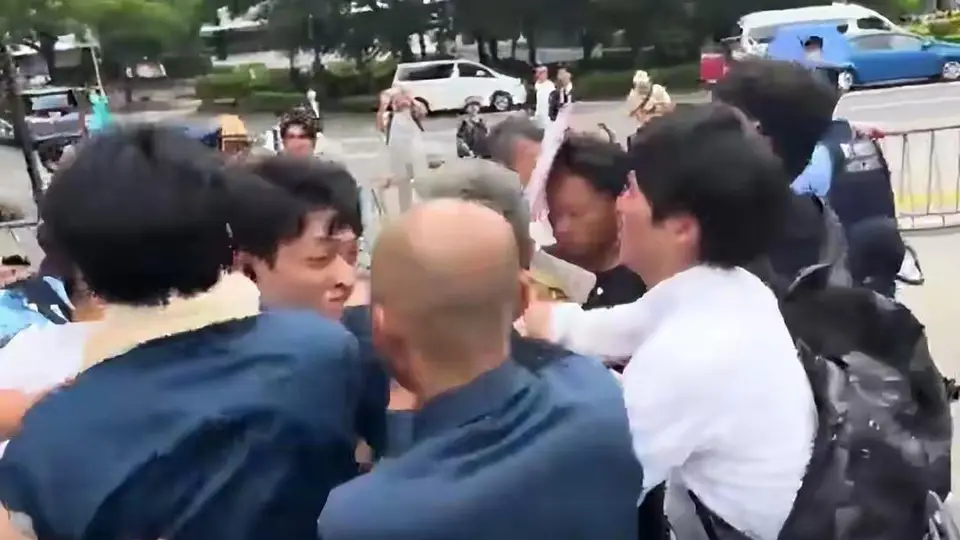 台湾一男子举着反华标语，内容是，欢迎日本再次侵华，在靖国神社附近游荡，结果被日本右翼分子抓住一顿围殴狠揍，原因是日本右翼分子根本不认识中文。